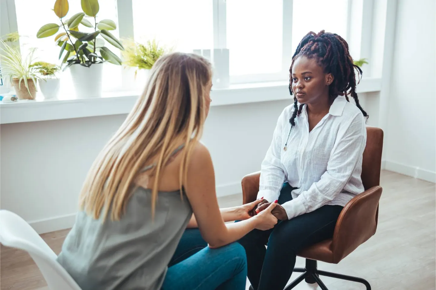 A young woman talking with a staff member in a bright office