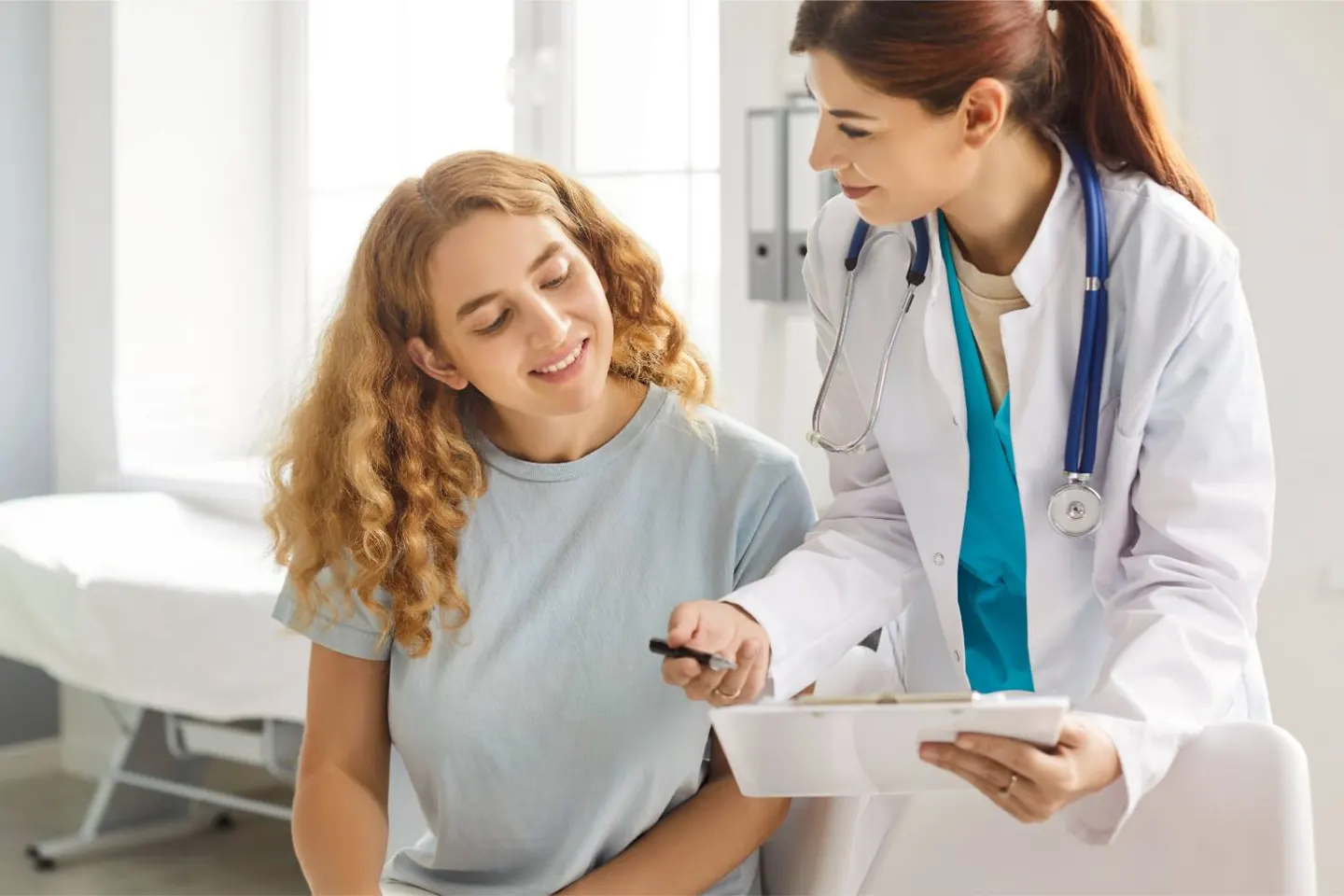 A clinician talking with a smiling young patient