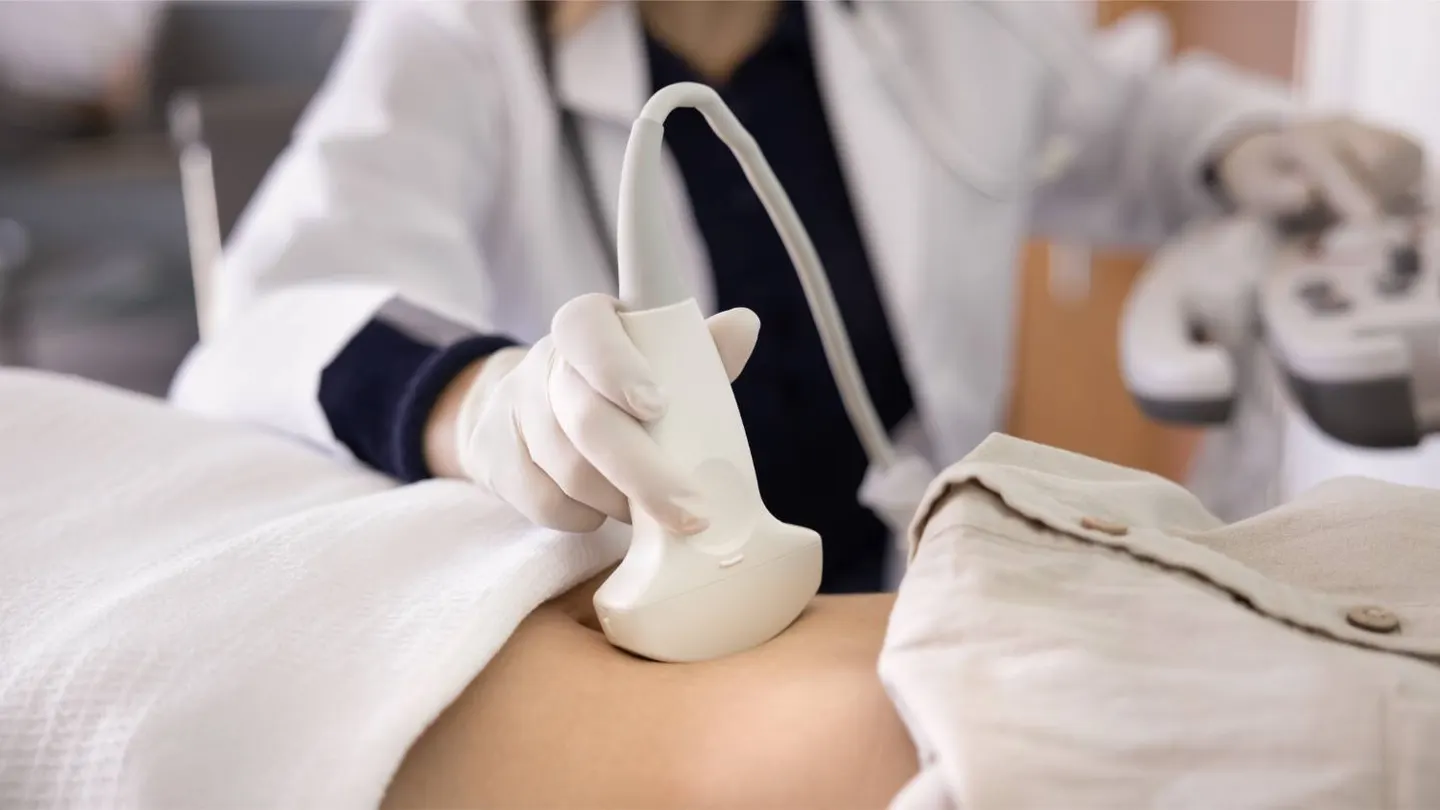 A medical professional holding an ultrasound probe