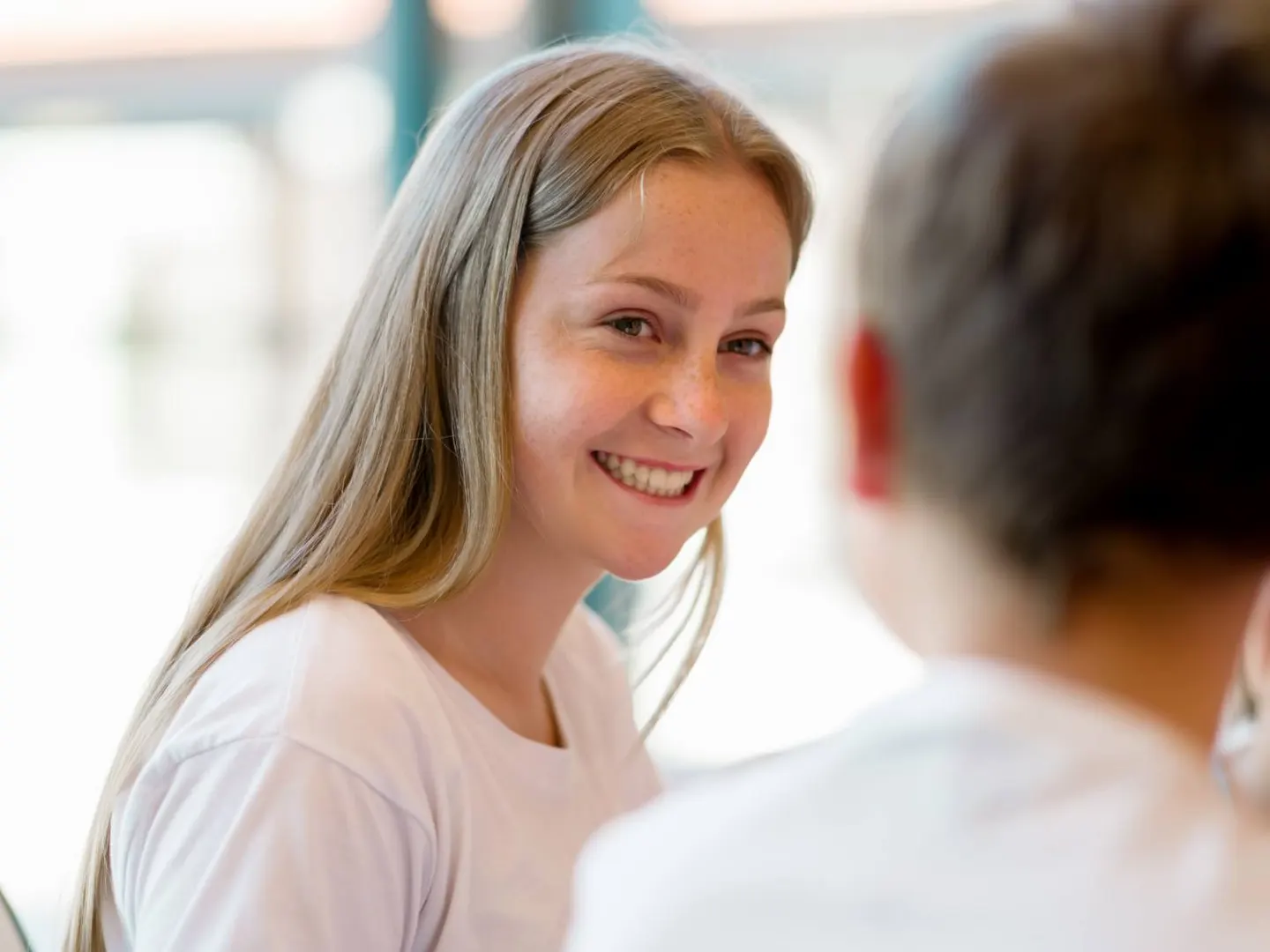 A young woman smiling during a conversation